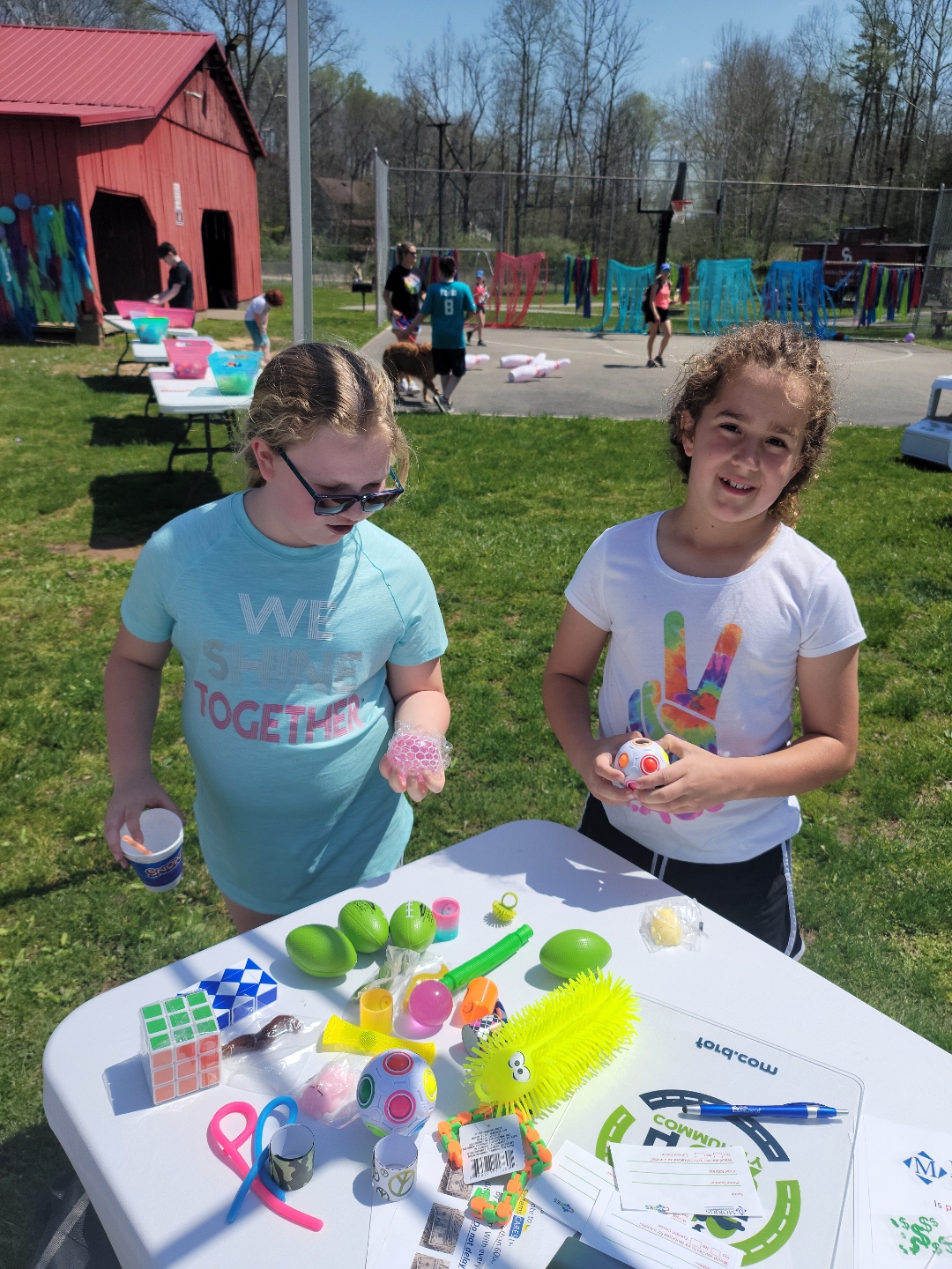 Two girls look over the table of prizes