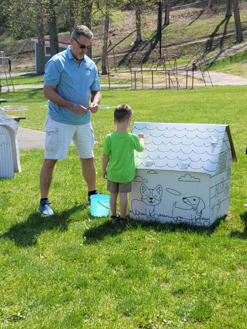 Walt supervises a child coloring a large dog house